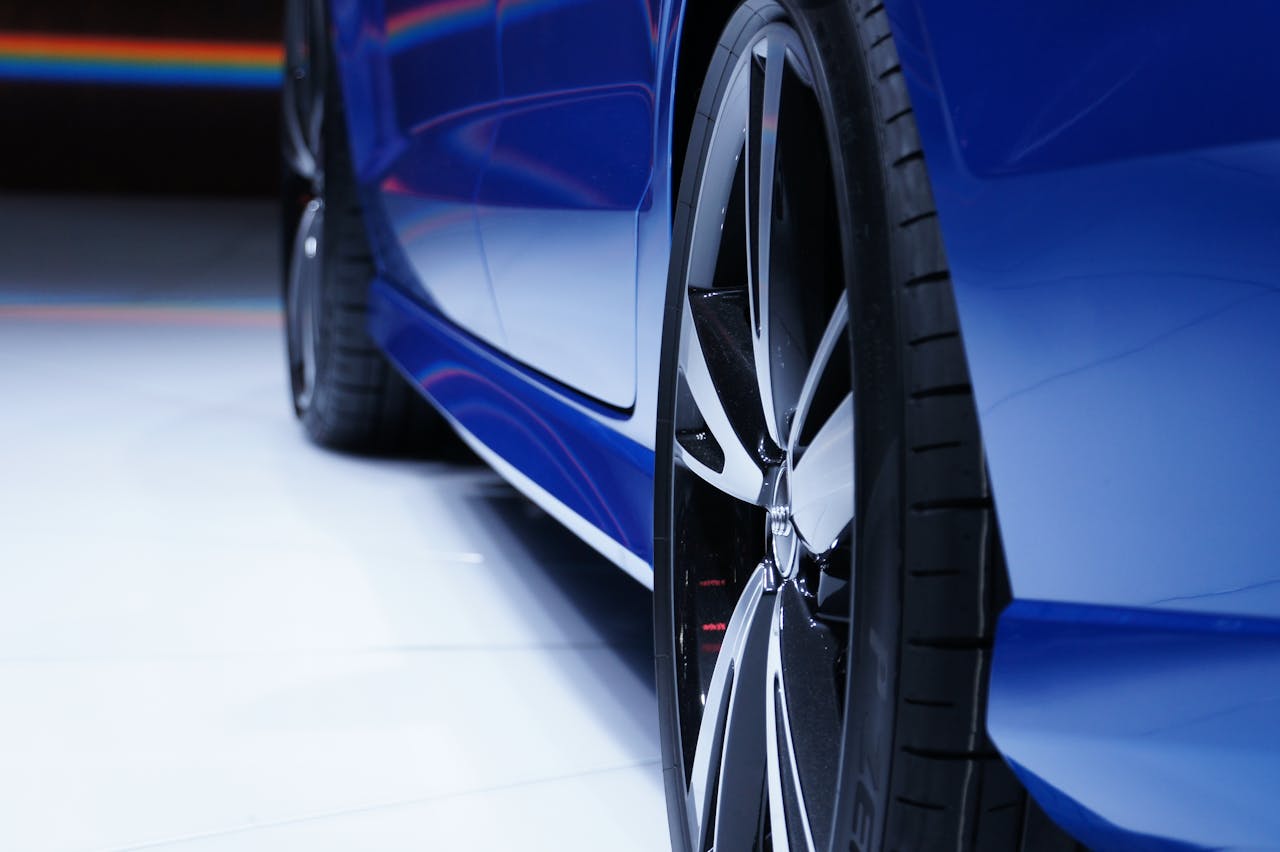 Home Close-up shot of a blue car highlighting the stylish alloy wheel. Perfect for automotive enthusiasts.